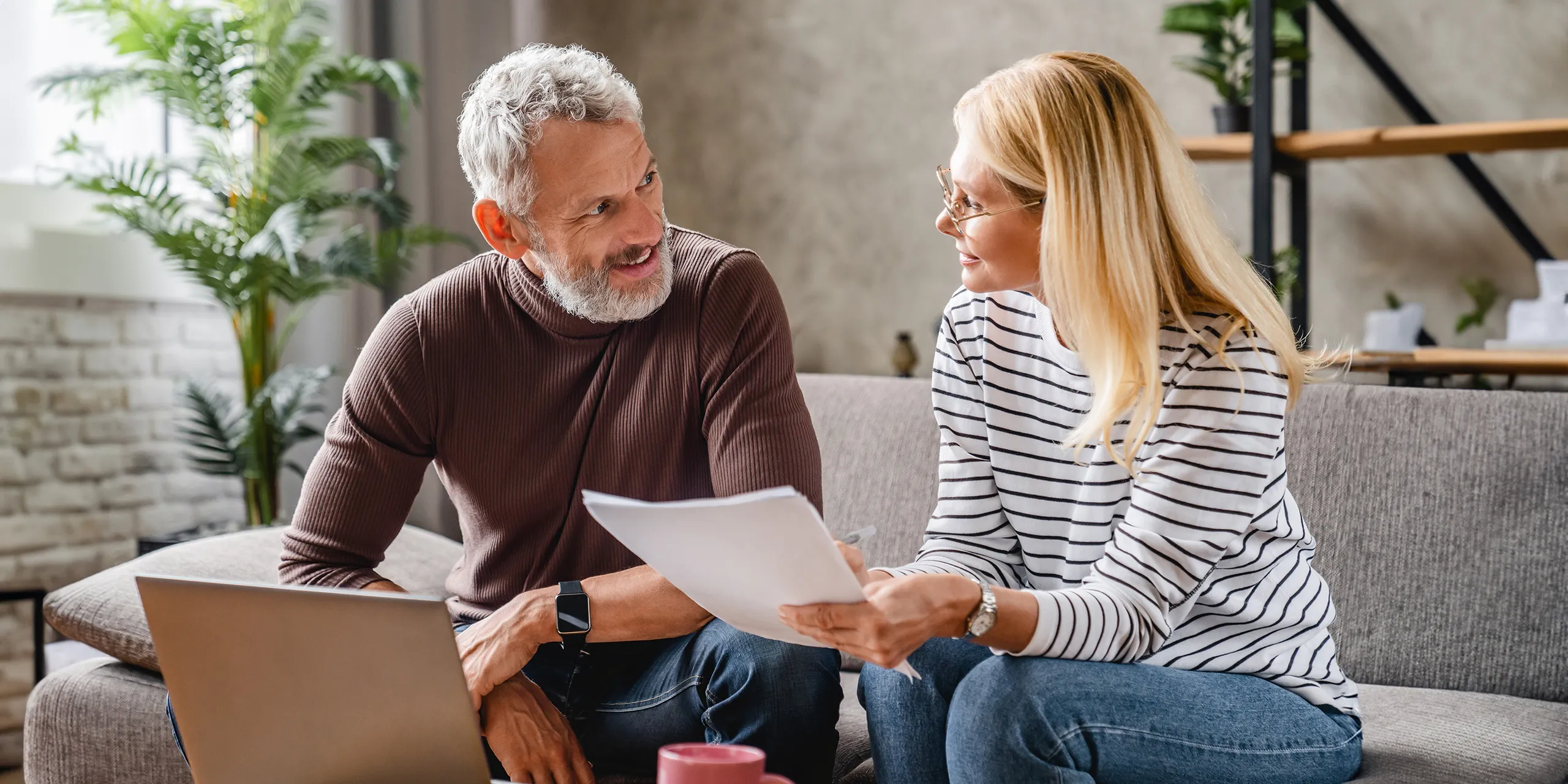 Paar auf der Couch am Laptop prüft Rentenanspruch